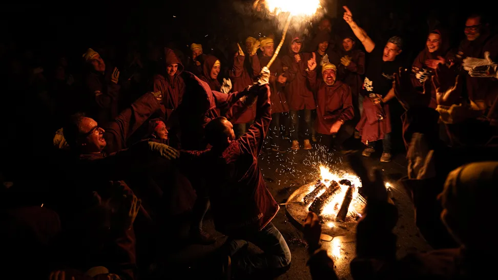 Una vez encendidas las antorchas, los fallaires desfilan hacia el casco antiguo de Andorra la Vella, ...